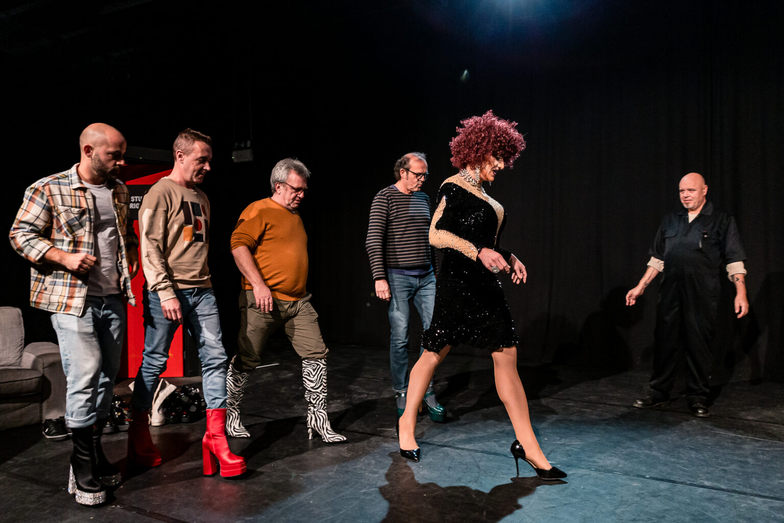 De cast van Mannen met Hakken leert dankzij Sally Monella de kneepjes van het hakkenlopen - © Backstage Producties