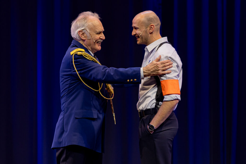 Michiel De Meyer floreert in de scènes die zich op het podium afspelen, waar Frans Maas en haast cartooneske hoofdcommissaris neerzet - © Backstage Producties